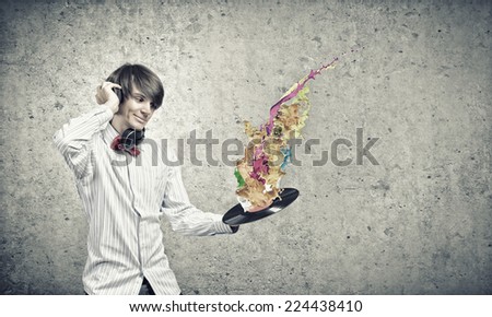 Young man dj wearing headphones and holding plate