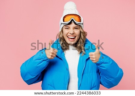Snowboarder woman wear blue suit goggles mask hat ski padded jacket spend extreme weekend showing thumb up like gesture isolated on plain pastel pink background. Winter sport hobby trip relax concept Royalty-Free Stock Photo #2244386033
