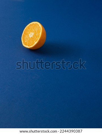 orange cut in half against royal blue background.Creative summer concept with copy space.