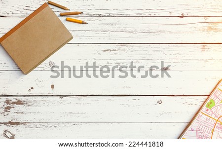 white empty wooden traveller's table with notebook and map, top view