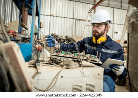 Team of engineers practicing maintenance Taking care and practicing maintenance of old machines in the factory so that they can be used continuously.
