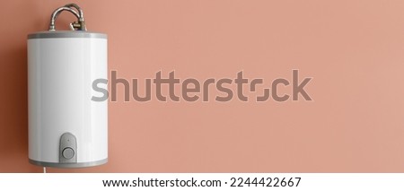 Modern electric boiler on brown background with space for text Royalty-Free Stock Photo #2244422667