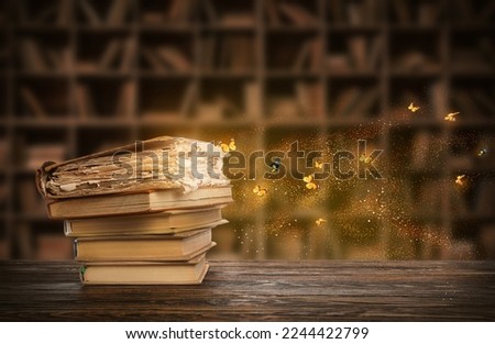 Old magic books with glow and flying butterflies in dark library