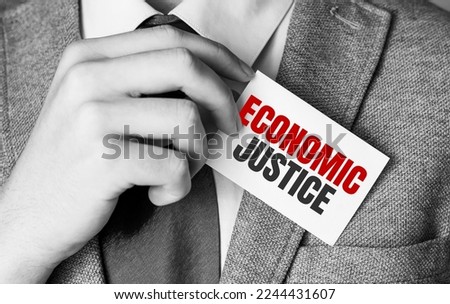 economic justice words on white business card and man hand