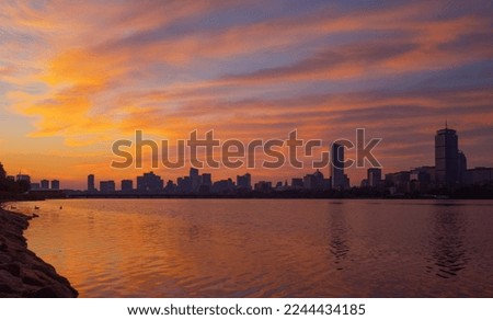 Boston city skyline during sunrise with Charles River in the foreground