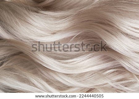 Young woman in a hairdressing salon dyes her hair blond Royalty-Free Stock Photo #2244440505