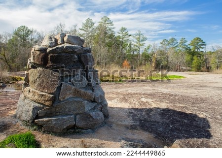 A solitary rock cairn trail marker at Arabia Mountain National Heritage Area near Atlanta, Georgia. (USA) Royalty-Free Stock Photo #2244449865