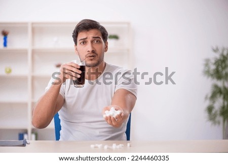 Young male student testing soft drink