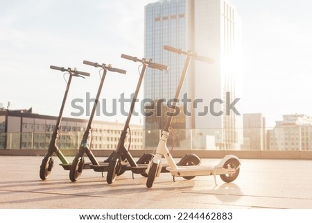 electric scooters stand on the street against the background of the city, transport of the future, eco transport rental Royalty-Free Stock Photo #2244462883