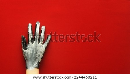 Painted hand on red background