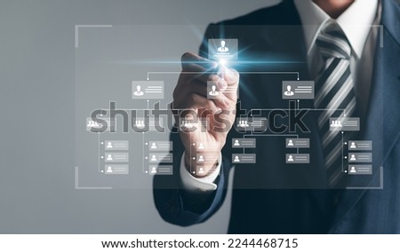 Businessman touching organization chart on virtual interface screen. Business process and workflow automation with flowchart. Hierarchical structure of teams and employees in the company. Royalty-Free Stock Photo #2244468715