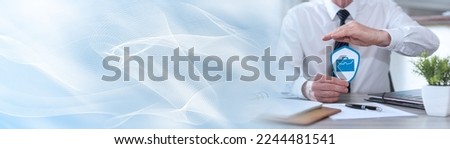 Concept of job loss insurance with paper shield protected by hand of insurer; panoramic banner Royalty-Free Stock Photo #2244481541