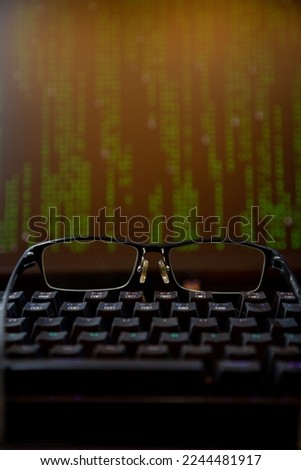 Computer screen with programming text keyboard and glasses, remote work, programmer concept, programming.