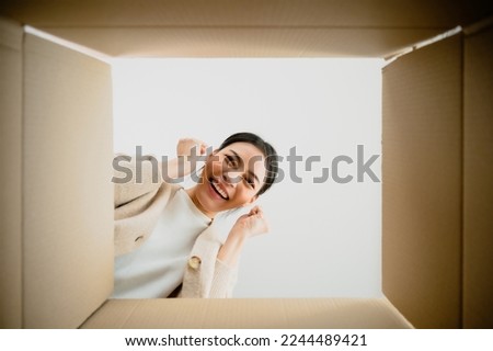 Surprised young asian woman unpacking. Opening carton box and looking inside. Packaging box, delivery service. Human emotions and facial expression Royalty-Free Stock Photo #2244489421