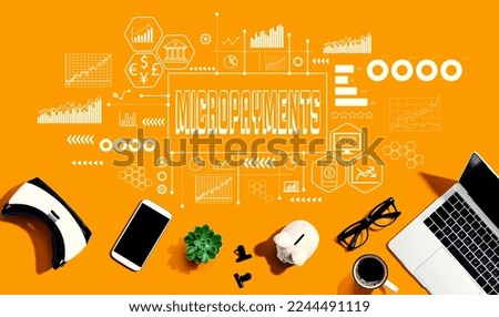 Micropayments theme with electronic gadgets and office supplies - flat lay Royalty-Free Stock Photo #2244491119