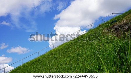 cloudy blue sky over green grass hill in december 2022                              