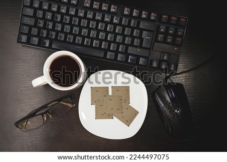 work desk, coffee cup and microprocessors on a plate. computer screen with programming text, CMD, keyboard and sleep glasses, programming concept and computer science.