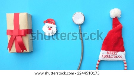 medical stethoscope with gift box,santa claus , red Santa claus hat hair  isolate on a blue background. Health care,christmas and new year concept