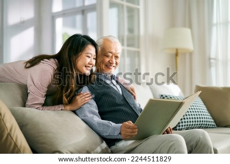 asian adult daughter and senior father enjoying conversation and good time at home Royalty-Free Stock Photo #2244511829