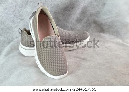 The picture shows shoes, a pair of women's gray slip-ons.