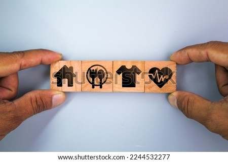 wooden cube with icons of food, Clothing, housing, medicine, four basic human needs concepts. Four Basic Human Material Needs. Royalty-Free Stock Photo #2244532277