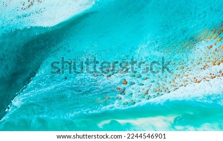 Artistic texture painted with liquid acrylic paints. Fluid art for background, wallpapper or poster. Backdrop similar to the landscape of the ocean. Sea artwork with turquoise waves and white foam.
