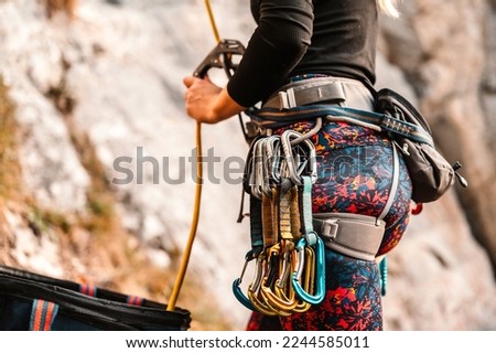 Climber wearing in climbing equipment. Practicing rock-climbing on a rock  mountain wall. Climbing sports  rock climber climbs on a rocky wall. Safety during climbing Royalty-Free Stock Photo #2244585011