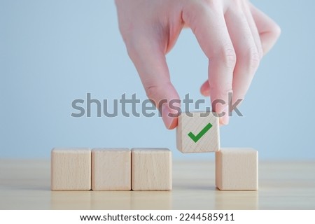 Elections and Voting, Vote, to do list, checklist, Task list, Survey and assessment concept. Hand pick green check mark on wooden block.