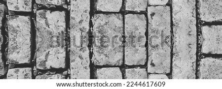 Vintage Brick Masonry Wall, Cracked bricks and stones, with a Weathered Surface. Rusty Stone Wall. Symmetrical Web Banner. Monochrome. Copy Space