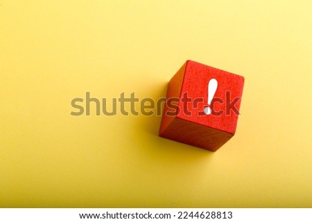 Red block with exclamation mark isolated on yellow background with copy space. Royalty-Free Stock Photo #2244628813