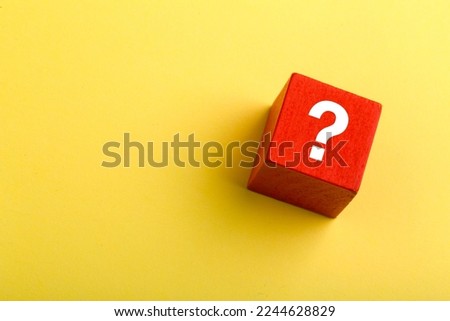 Red block with question mark isolated on yellow background with copy space.