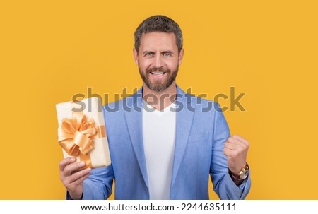 glad guy with present box for holiday. photo of guy holding occasion present box.