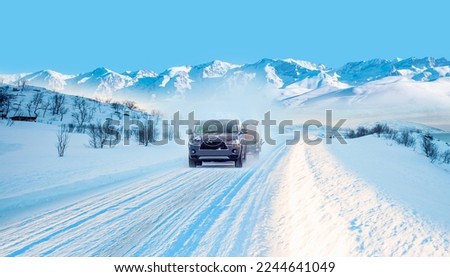 Car (SUV) moving on snowy road  with small trailer at the winter - Tromso, Norway