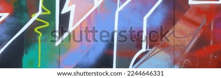 Colorful background of graffiti painting artwork with bright aerosol strips on metal wall. Old school street art piece made with aerosol spray paint cans. Contemporary youth culture backdrop Royalty-Free Stock Photo #2244646331