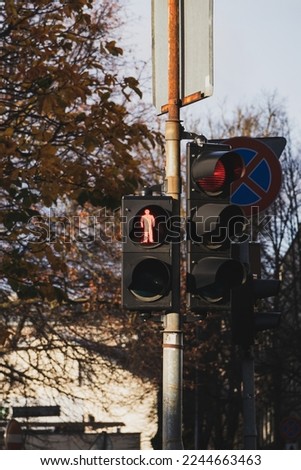 Traffic light with red light. A traffic light with a red human symbol that prohibits crossing the street. Soft focus.