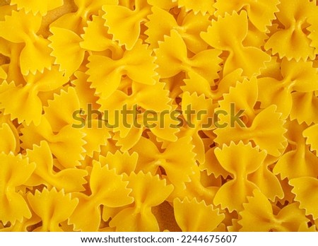 Raw Farfalle Pasta Texture Background, Yellow Dry Butterfly Noodles Pattern, Wheat Bow Macaroni Mockup, Uncooked Farfalle Background Top View, Copy Space Royalty-Free Stock Photo #2244675607