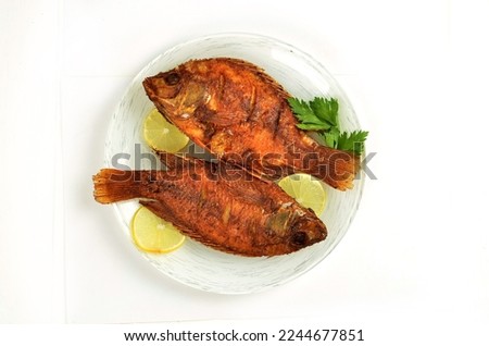 Popular Indonesian dish of fried fish isolated on white background