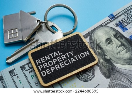 Key, cash and plate with sign Rental property depreciation. Royalty-Free Stock Photo #2244688595