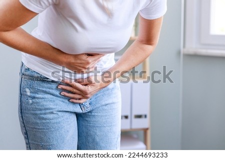 Young woman having painful stomach ache. Chronic gastritis. Stomach or menstrual cramps. Abdomen bloating concept. Royalty-Free Stock Photo #2244693233
