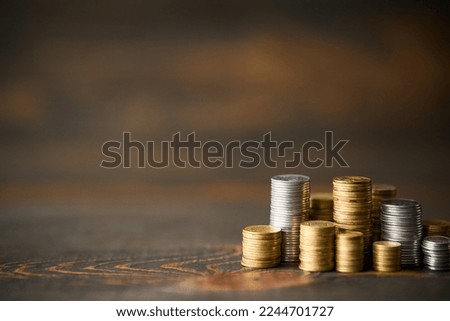 Coins stacks with copy space for text on wooden background. Finance, banking and investment concept.