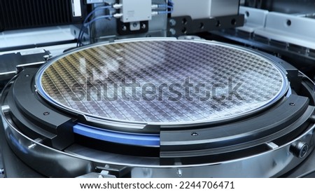 Close-up Shot of a Silicon Wafer inside Photolithography Machine. Shot of Wafer during Semiconductor and Computer Chip Manufacturing at Fab or Foundry. Royalty-Free Stock Photo #2244706471