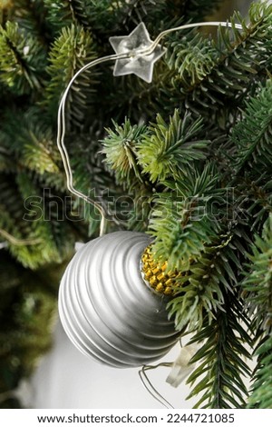Silver ball and star shaped led light closeup on artificial christmas tree