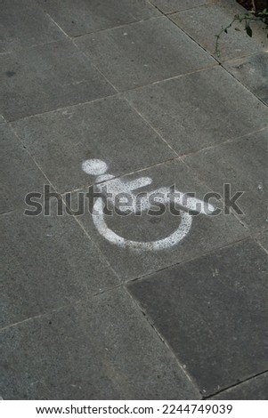 Wheelchair icon on the natural stone floor seen from the left