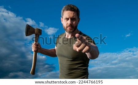 man threaten with axe. caucasian man hold ax. brutal man on sky background. point finger Royalty-Free Stock Photo #2244766195