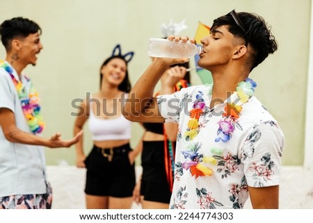 Brazilian Carnival. Person drinking water during carnival block on the street Royalty-Free Stock Photo #2244774303
