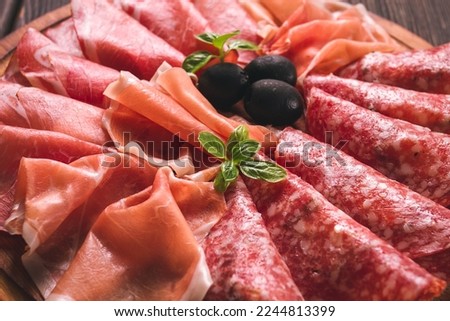 Assortment , sliced meat appetizer, prosciutto, salami and ham, with olives, breakfast, top view, close-up, no people, Royalty-Free Stock Photo #2244813399