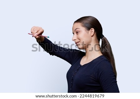 Teenage girl student with a pencil draws on an abstract screen