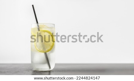 Refreshing Homemade Lemonade Made Of Lemon Slices, Sparkling Water Served In Glass With Metal Straw On Against Gray Wall. Image With Copy Space Royalty-Free Stock Photo #2244824147