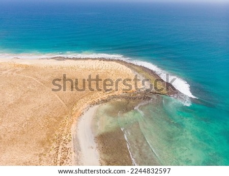Coast of Boa Vista - paradise island next to the west coast of Africa. Nice waves and surf around the shore of Cape Verde island. Drone image of the Boa vista coast. Perfect sunny weather! Royalty-Free Stock Photo #2244832597