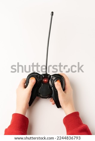 Game radio remote control in a kid hands. Royalty-Free Stock Photo #2244836793